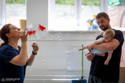 In addition to posture, the assessment covers the ability to focus attention. Rattles, singing, and bubble blowers are all great tools for this. The bubble blower is one of Ildikó’s most useful aids. First of all, noticing the bubbles is a good indicator of visual development. Secondly, the spectacle of the bubbles captivates little ones so much that they usually stop crying, allowing the real work to continue.